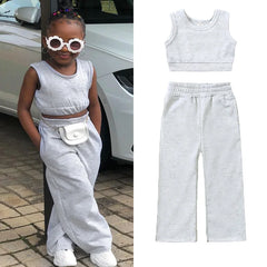A young girl wears a grey sleeveless crop top and matching wide-leg sweatpants.