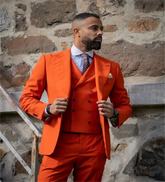 A man wears a dark orange three-piece suit with a peak lapel, striped shirt, and polka dot tie.