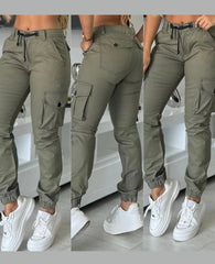 A woman wears olive green slim-fit cargo pants with multiple pockets and cuffed ankles.