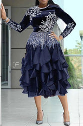 A navy blue velvet midi dress with long sleeves, rhinestone embellishments, and a ruffled skirt.