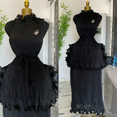 A black sleeveless pleated midi dress with a ruffled peplum waist and a matching tie belt.