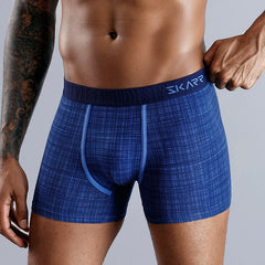 A man wears blue patterned cotton boxer shorts with a branded elastic waistband.