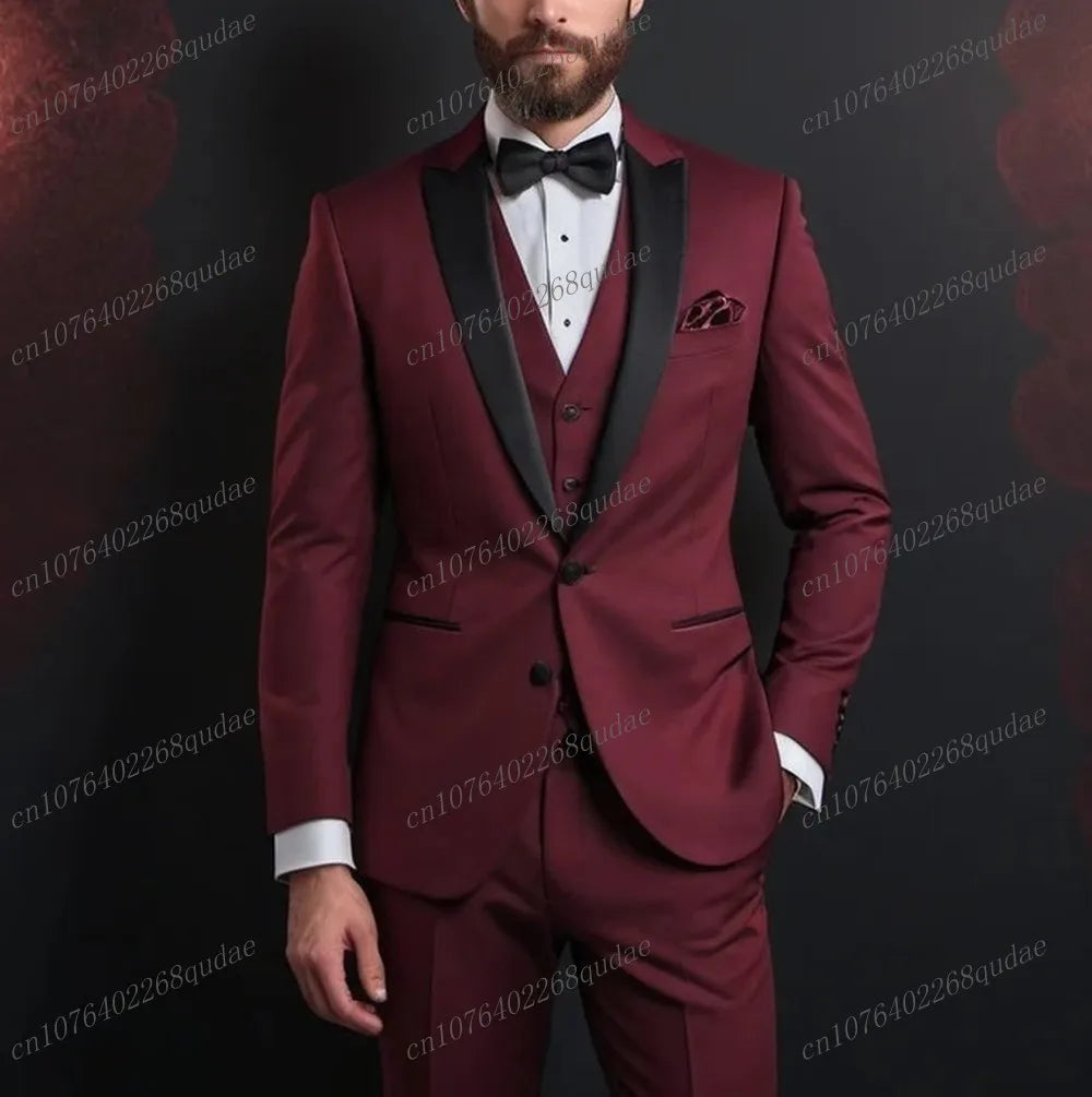 A man wears a three-piece burgundy suit with a black shawl collar, white shirt, and black bow tie.