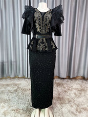 A black ankle-length dress with gold rhinestone embellishments, ruffled sleeves, and a belt.