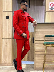 A man wears a slim-fit red suit featuring a unique asymmetrical button-down jacket and trousers.