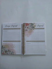 An open spiral-bound prayer journal with floral accents and lined pages for daily requests.