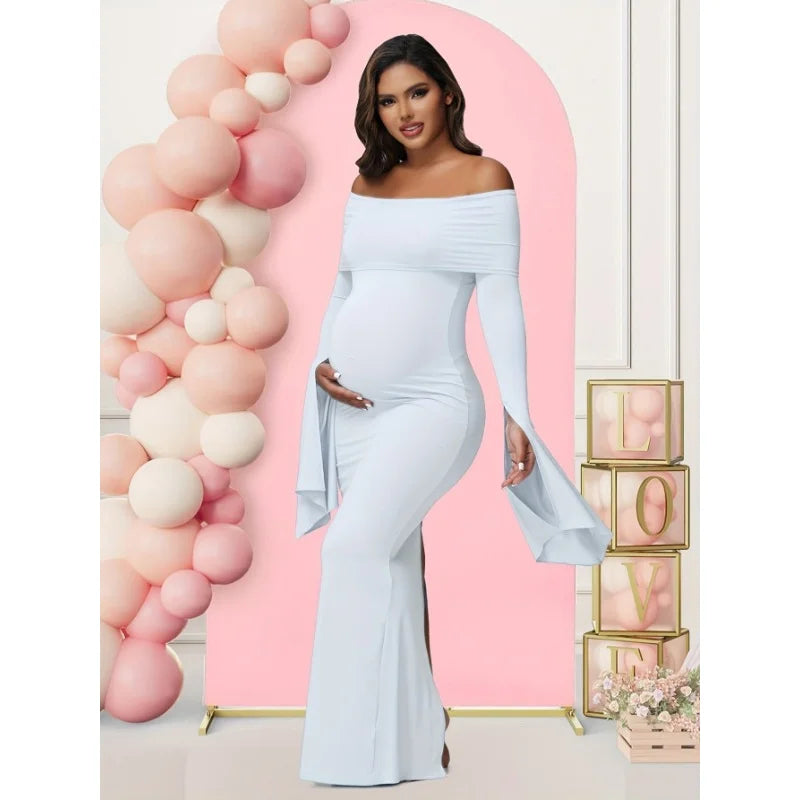 A pregnant woman wears a solid white off-shoulder long-sleeve mermaid maternity dress.