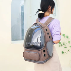 A person wears a brown nylon pet carrier backpack with a large transparent bubble window.