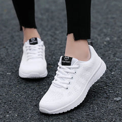 A pair of white lace-up sneakers with breathable mesh uppers and platform soles.