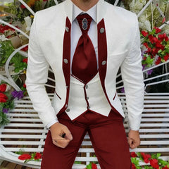 A man wears a three-piece suit featuring a white patterned jacket, a white vest, and burgundy trousers with a matching tie.