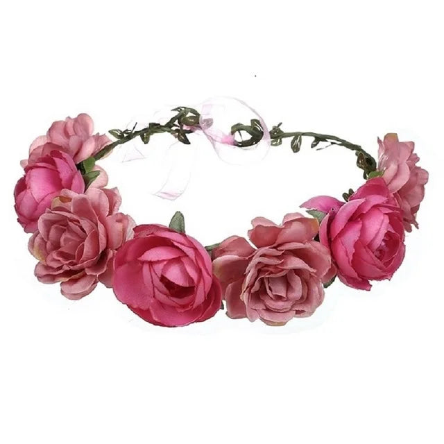 A floral crown featuring several pink fabric roses attached to a thin, vine-like headband.