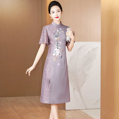 A woman wears a purple satin cheongsam with lace detailing, short sleeves, and floral embroidery.