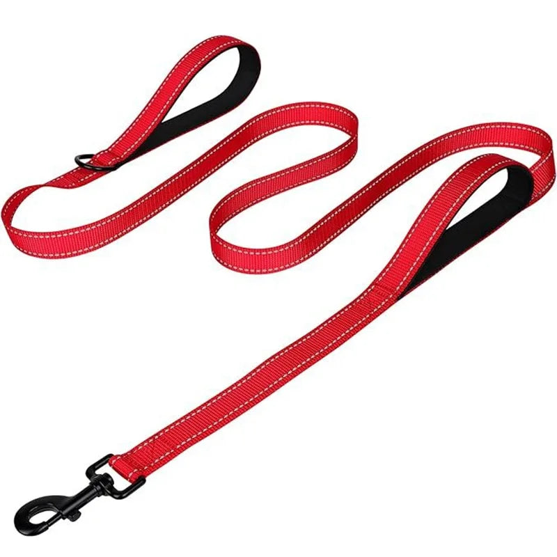 A red nylon dog leash with two padded handles and reflective stitching on a white background.