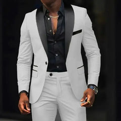 A man wears a white slim-fit suit with a black shawl lapel and a black button-down shirt.