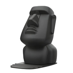 A matte black Moai statue phone stand with a grooved base for holding a smartphone.