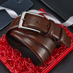 A brown genuine leather belt with a silver alloy needle buckle resting in a gift box.