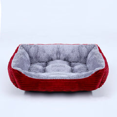 A rectangular pet bed with a red corduroy exterior and a soft, grey plush interior.