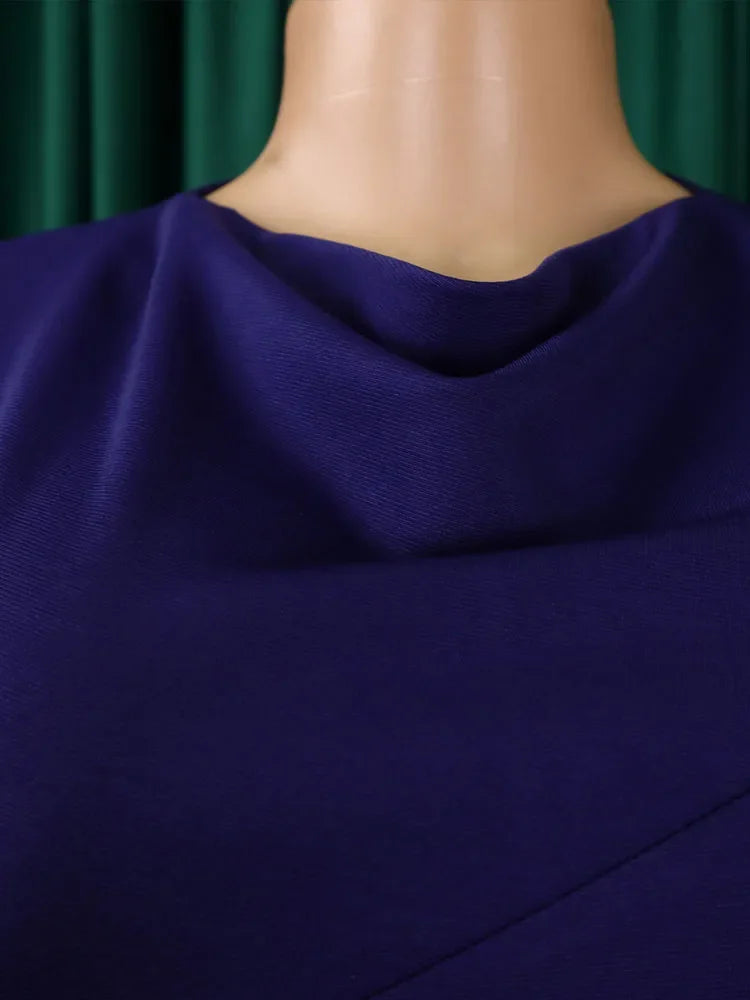 A close-up of a solid purple dress featuring a draped cowl neckline.