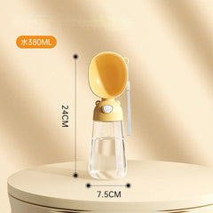 A portable yellow and clear plastic pet water dispenser with a built-in drinking bowl.