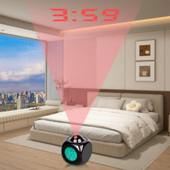 A black cube-shaped digital alarm clock projects the time onto the wall of a bedroom.