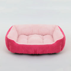 A rectangular pet bed with a bright pink corduroy exterior and a soft, light pink plush interior.