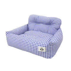 A purple and white gingham patterned pet bed with raised sides and a small bear logo tag.