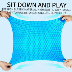 A blue, flexible, honeycomb-patterned TPE gel seat cushion being stretched by two pairs of hands.