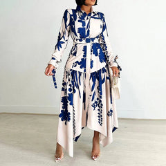 A woman wears a long-sleeved, ankle-length shirt dress with a blue and white floral print.