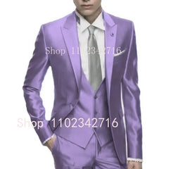 A man wears a slim-fit, three-piece lavender satin suit with a white shirt and silver tie.