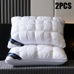 Two white hotel-style bed pillows with tufted tops and blue branded trim stacked on a bed.