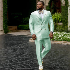 A man wears a mint green double-breasted suit with a white shirt and gold bow tie.
