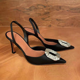 Black silk pointed-toe stiletto heels featuring a crystal-embellished buckle and back strap.