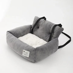 A grey and white plush car pet seat with black adjustable straps on a white background.