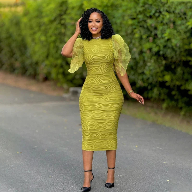 A woman wears a lime green, mid-calf bodycon dress with ruffled butterfly sleeves and a textured finish.