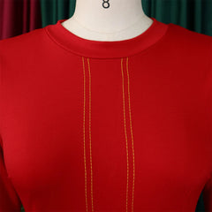 A close-up of a red O-neck dress featuring two vertical rows of yellow decorative stitching.