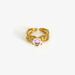 A gold-plated open ring featuring a central iridescent moonstone in a vintage geometric setting.