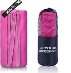 A pink microfiber sports towel shown unfolded and packed inside a black mesh carrying bag.