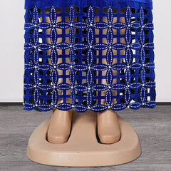 A blue velvet maxi dress featuring a laser-cut geometric pattern embellished with small rhinestones.