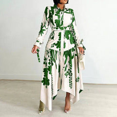A woman wears an ankle-length, long-sleeved shirt dress with a green and white botanical print.