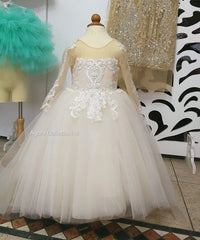 A floor-length white flower girl dress with a lace bodice, long sheer sleeves, and a tulle skirt.
