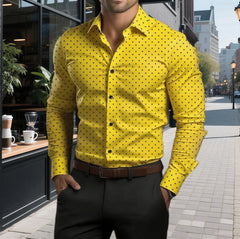 A man wears a long-sleeved yellow button-down shirt with a black polka dot pattern.