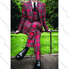 A man wears a three-piece red plaid suit with a peak lapel jacket, vest, and matching trousers.