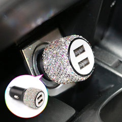 A dual USB car charger decorated with sparkling rhinestones, shown plugged into a vehicle console.