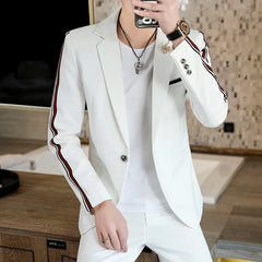 A man wears a white slim-fit suit jacket featuring black and red striped detailing along the sleeves.