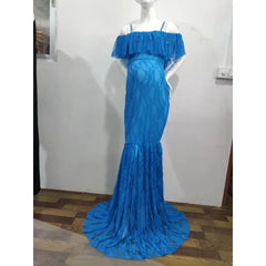 A bright blue lace maternity gown with an off-the-shoulder ruffled neckline and a flared hem.