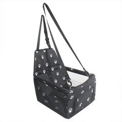 A black foldable pet car seat carrier with a white paw print pattern and adjustable straps.