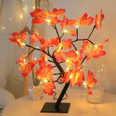 A decorative maple leaf tree lamp with warm LED lights on a black base.