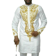 A man wears a white long-sleeve African-style tunic with gold embroidery on the chest and cuffs.