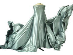 A mannequin displays a long, flowing piece of sage green satin fabric used for maternity photos.