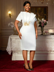 A woman wears a white, mid-calf bodycon dress with ruffled bodice detailing and gold appliques.